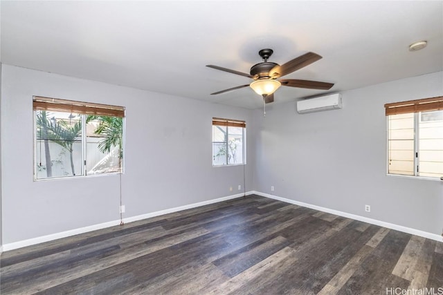 spare room with baseboards, dark wood finished floors, and a wall unit AC