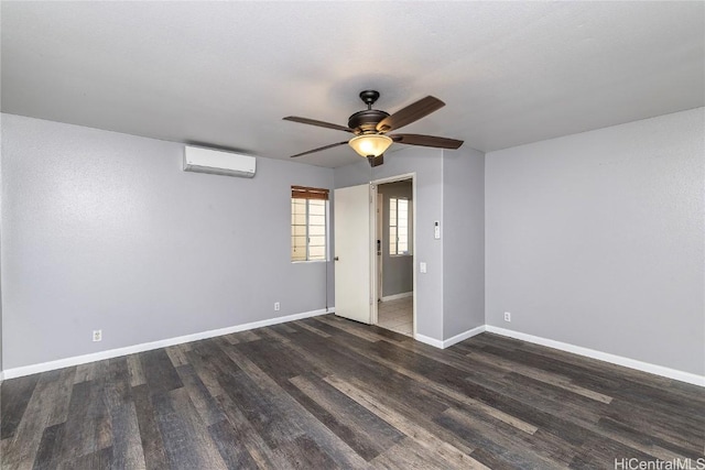 unfurnished bedroom featuring a wall mounted air conditioner, a ceiling fan, baseboards, and wood finished floors