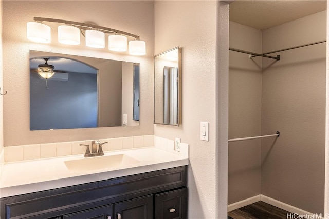 bathroom with vanity, wood finished floors, baseboards, and ceiling fan