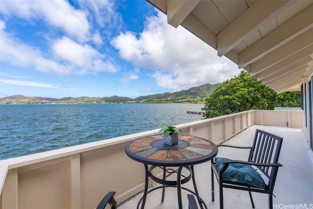 balcony featuring a water and mountain view