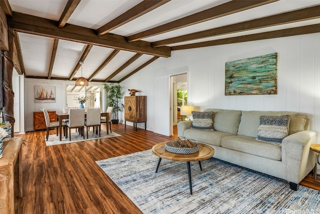 living area with lofted ceiling with beams and wood finished floors