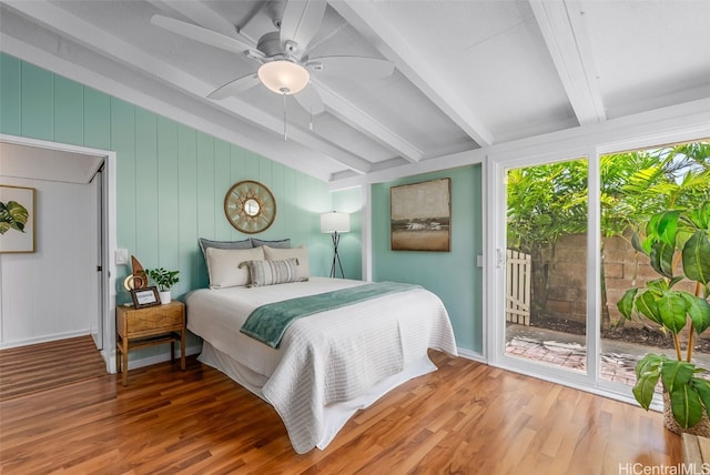 bedroom with ceiling fan, wood finished floors, beam ceiling, and access to exterior