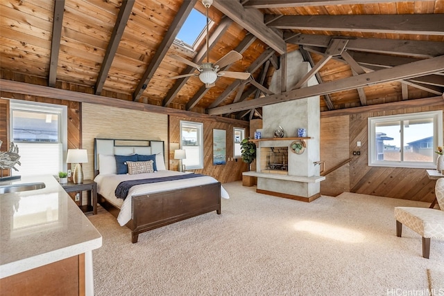 carpeted bedroom featuring wooden ceiling, vaulted ceiling with skylight, a fireplace, and wood walls