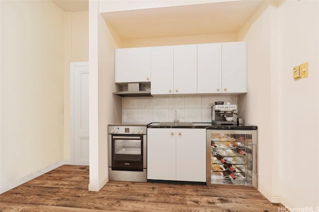 1088 Bishop St Unit 204, Honolulu, HI 96813 - kitchen with stainless steel electric range oven, wood finished floors, beverage cooler, a sink, and white cabinets