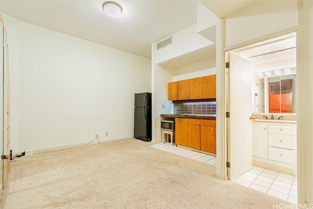 1088 Bishop St Unit 204, Honolulu, HI 96813 - kitchen featuring freestanding refrigerator, light carpet, stainless steel microwave, brown cabinets, and backsplash