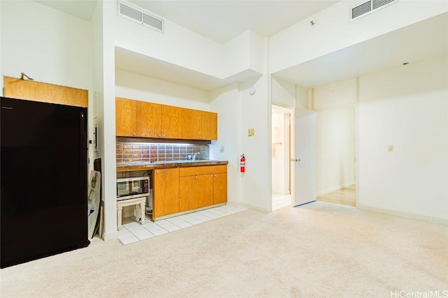 1088 Bishop St Unit 204, Honolulu, HI 96813 - kitchen with visible vents, light colored carpet, stainless steel microwave, and freestanding refrigerator