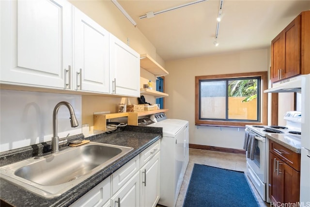 interior space featuring baseboards, laundry area, rail lighting, independent washer and dryer, and a sink