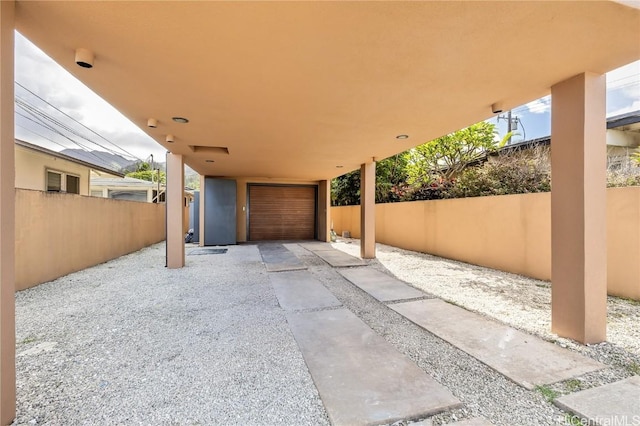 view of patio / terrace with a detached garage and fence