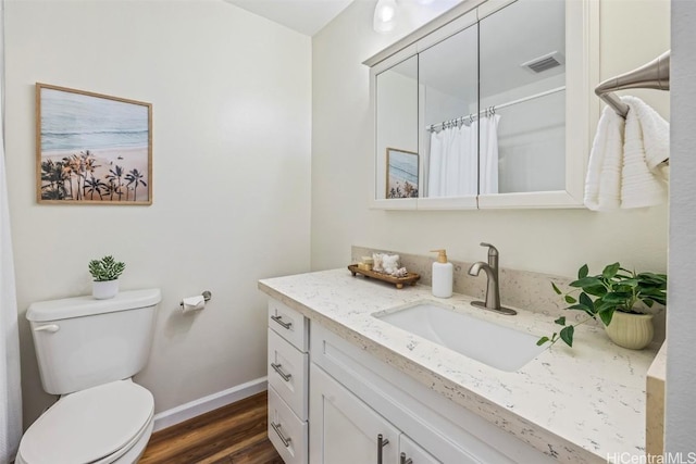 bathroom with visible vents, toilet, wood finished floors, baseboards, and vanity