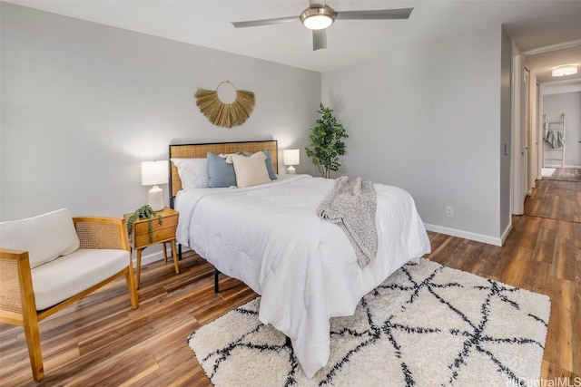 bedroom featuring a ceiling fan, baseboards, and wood finished floors