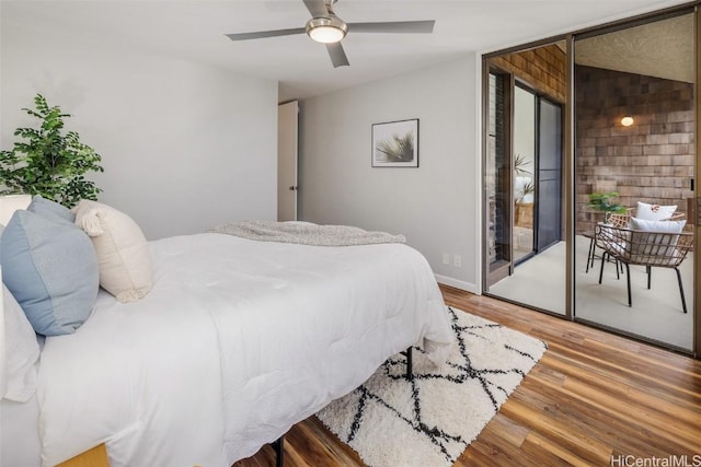 bedroom featuring access to outside, baseboards, a ceiling fan, and wood finished floors