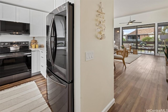 kitchen with wood finished floors, ceiling fan, stainless steel appliances, light countertops, and white cabinetry