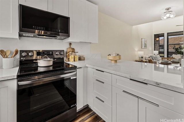 kitchen with light stone counters, stainless steel appliances, dark wood-style flooring, and white cabinetry