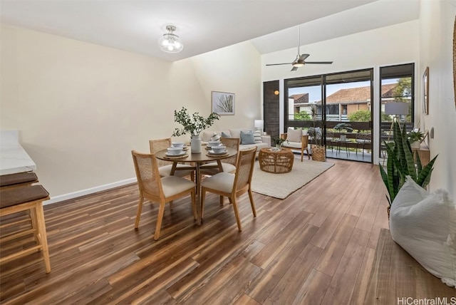 dining space featuring ceiling fan, lofted ceiling, baseboards, and wood finished floors