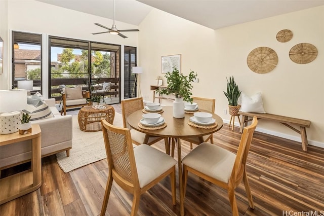 dining room with ceiling fan, baseboards, wood finished floors, and vaulted ceiling