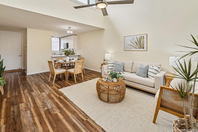 living room with baseboards, wood finished floors, and a ceiling fan