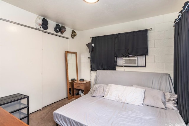 bedroom featuring carpet flooring and concrete block wall