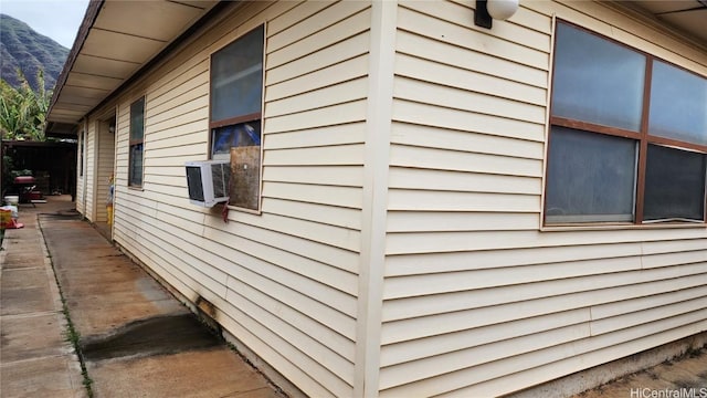 view of side of home featuring cooling unit and a mountain view