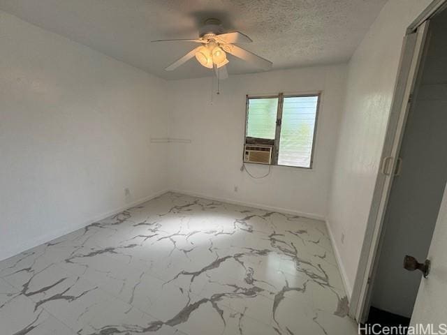 empty room with baseboards, cooling unit, marble finish floor, a textured ceiling, and a ceiling fan