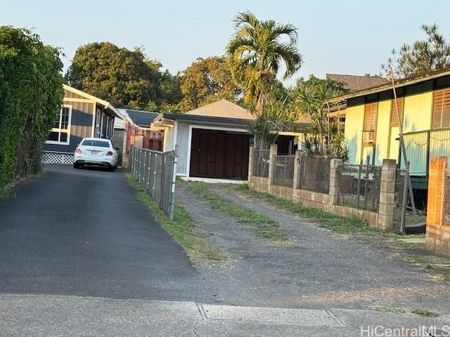 view of front facade with driveway and fence