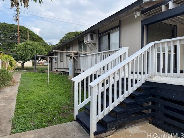 view of side of property with an AC wall unit and a yard