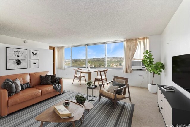 living area with light colored carpet, cooling unit, and a textured ceiling