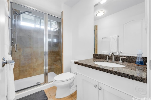 bathroom with tile patterned flooring, toilet, vanity, and a stall shower