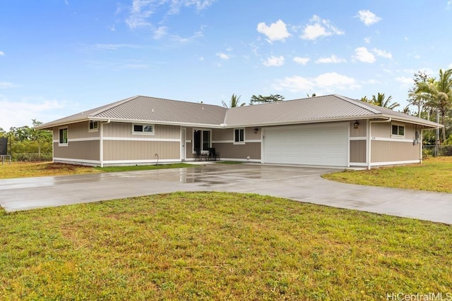 ranch-style house with a garage, metal roof, concrete driveway, and a front lawn