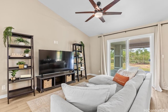 living room with baseboards, light wood finished floors, a ceiling fan, and vaulted ceiling