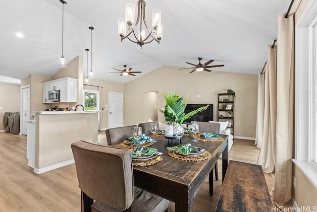 dining space featuring baseboards, lofted ceiling, light wood-style flooring, ceiling fan, and washer and dryer