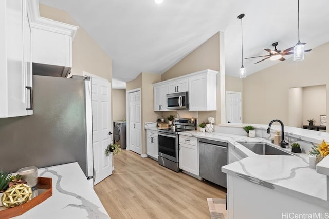 kitchen featuring washer and clothes dryer, white cabinets, stainless steel appliances, and a sink