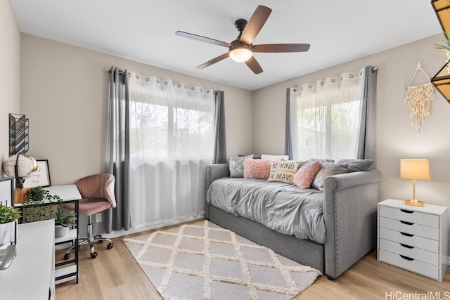 living area with a ceiling fan and wood finished floors