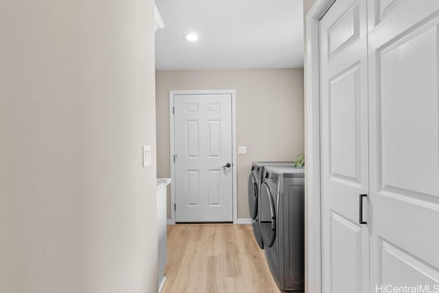 clothes washing area featuring baseboards, light wood-type flooring, laundry area, recessed lighting, and separate washer and dryer