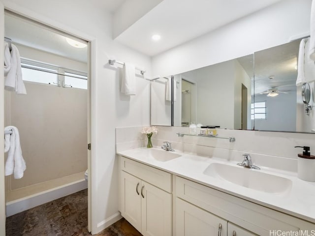 bathroom featuring a sink, toilet, a shower stall, and double vanity