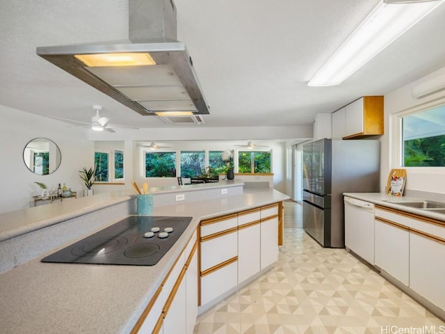 kitchen featuring light floors, white dishwasher, extractor fan, black electric cooktop, and a wealth of natural light