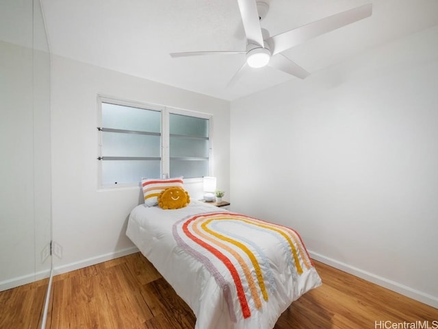 bedroom with ceiling fan, baseboards, and wood finished floors