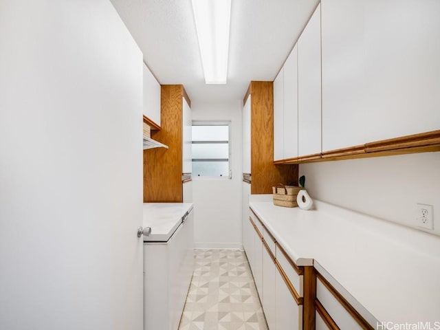 laundry area featuring cabinet space and light floors