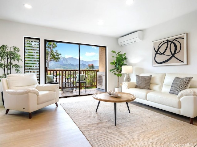 living area with a mountain view, recessed lighting, light wood-type flooring, and a wall mounted air conditioner