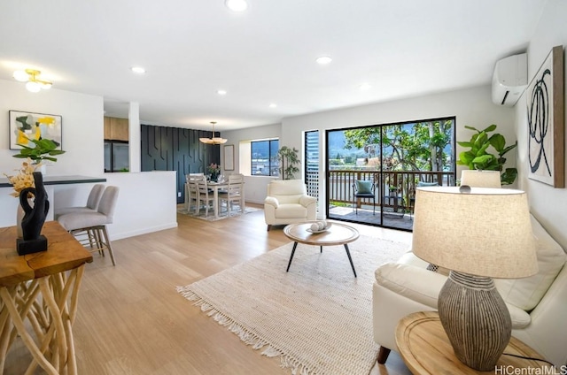 living room with recessed lighting, a wall mounted air conditioner, and light wood-type flooring