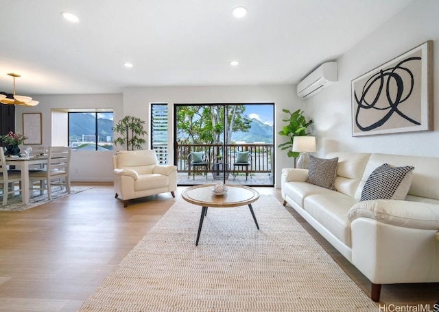 living room featuring an AC wall unit, recessed lighting, and wood finished floors