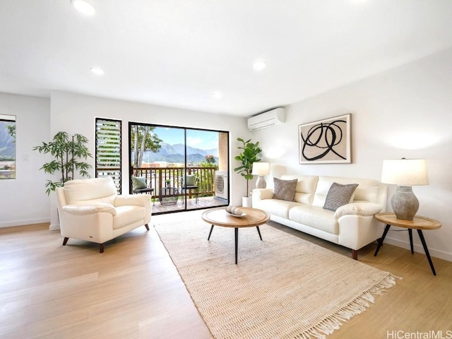 living area with baseboards, recessed lighting, a wall mounted air conditioner, and light wood-style floors