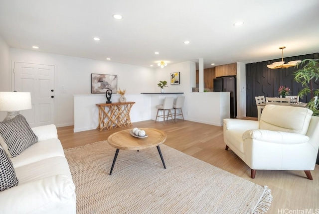 living area featuring recessed lighting, light wood-style flooring, and baseboards