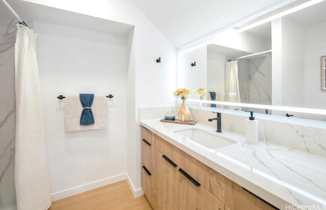 full bathroom with baseboards, a shower with curtain, wood finished floors, and vanity