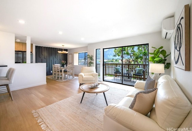 living area featuring recessed lighting, light wood-type flooring, baseboards, and an AC wall unit