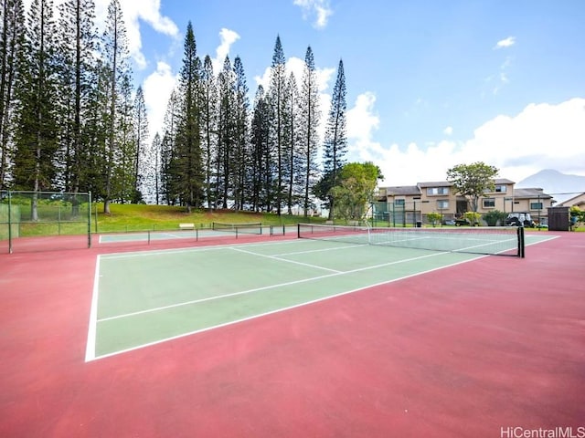 view of tennis court featuring community basketball court and fence