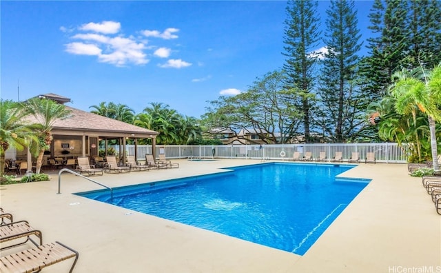 pool with a patio and fence