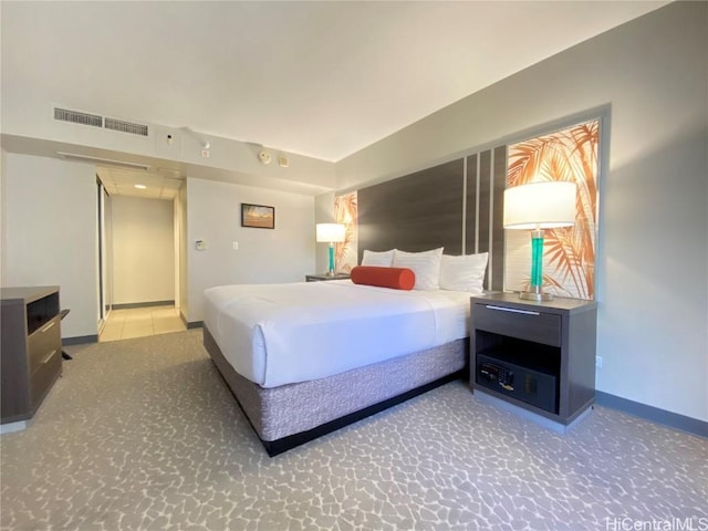 bedroom featuring visible vents, light colored carpet, and baseboards