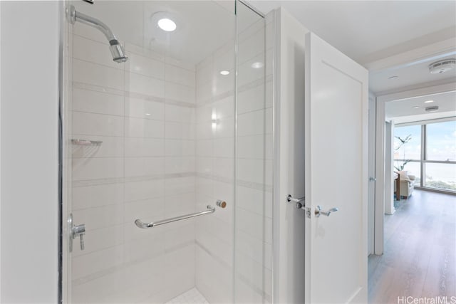 full bathroom with wood finished floors and a shower stall