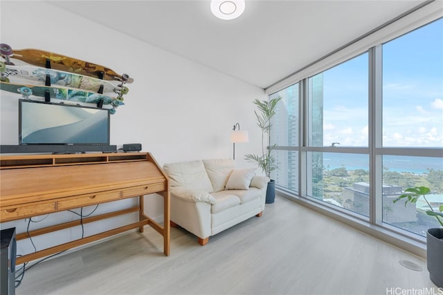 living area with expansive windows, baseboards, and wood finished floors