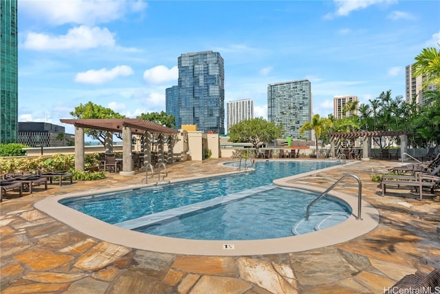 community pool featuring a city view, a pergola, and a patio